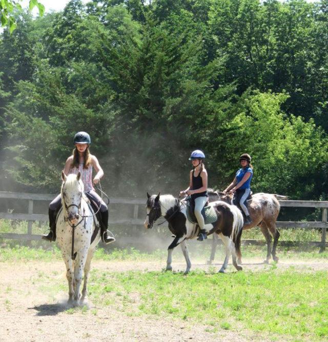 Three girls riding horses