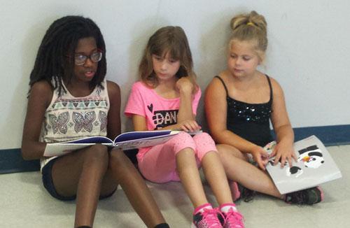 Three girls reading books