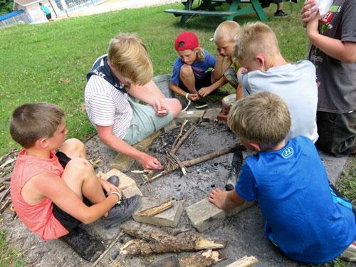 Boys starting a fire in a circle