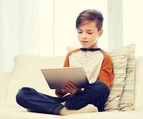 boy with tablet sitting on couch